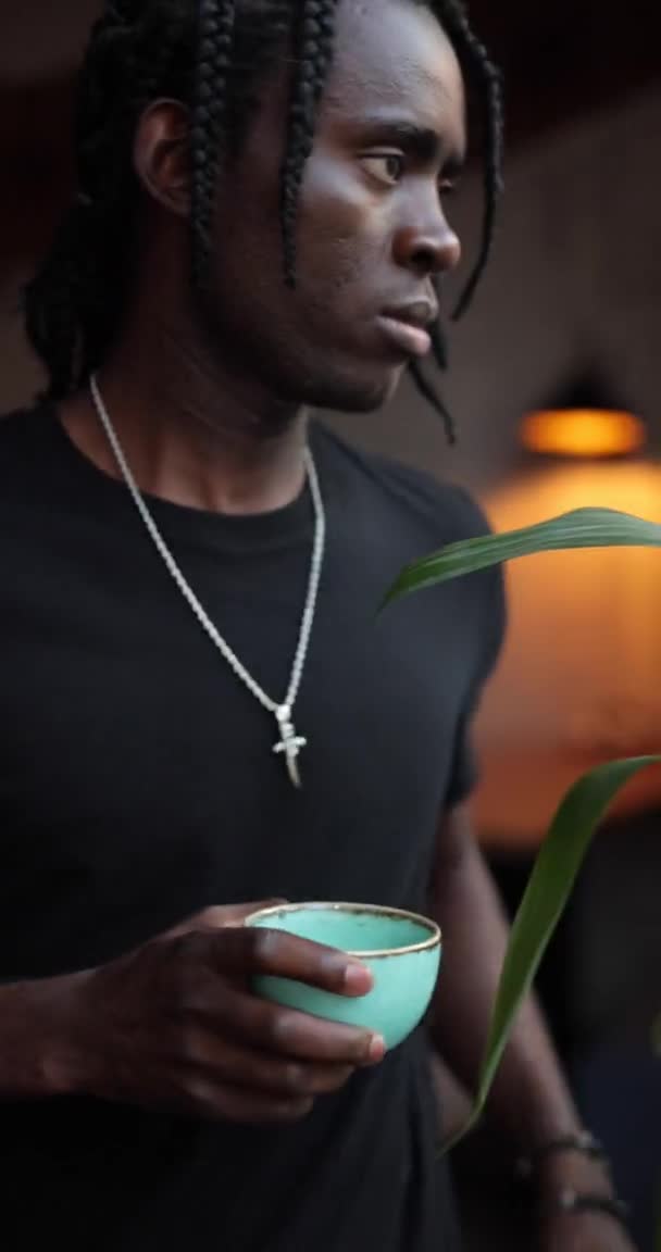Verticale video Afro-Amerikaanse man drinkt thee in een cafe — Stockvideo