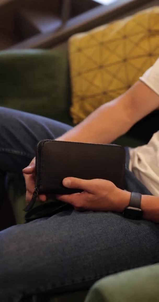 Man maakt zijn portemonnee los en neemt smartphone — Stockvideo