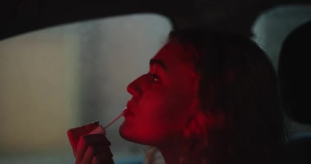 Woman paints her lips at night in a car — Stock Video