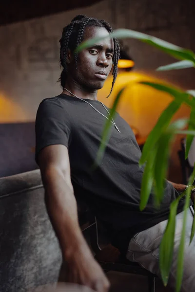 Портрет африканца с дредами, сидящего на стуле — стоковое фото