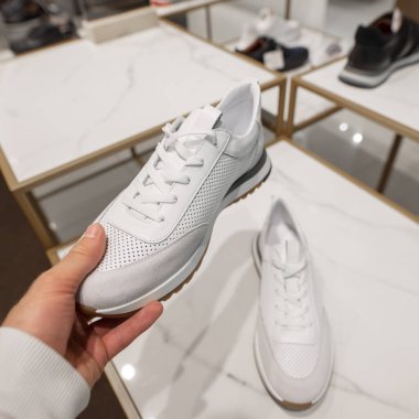 Pov erkeği mağazada yeni bir spor ayakkabı seçiyor.