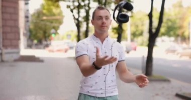 Adam şehirde büyük kulaklıklar takıyor.