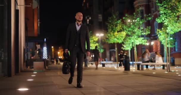 El hombre de traje clásico va con una bolsa de dinero en la ciudad de la noche — Vídeos de Stock