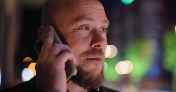 Szekrény férfi beszél okostelefonnal az éjszakai városban — Stock videók
