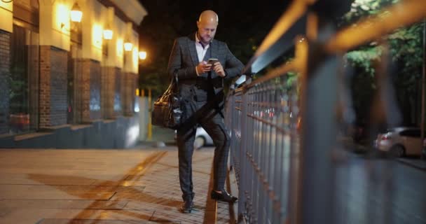 Businessman using smartphone at the night city — Stock Video