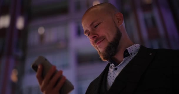 Üzletember okostelefont használ az éjszakai városban — Stock videók
