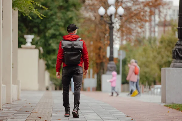 Visszapillantás férfi hátizsákkal séta őszi sikátorban — Stock Fotó