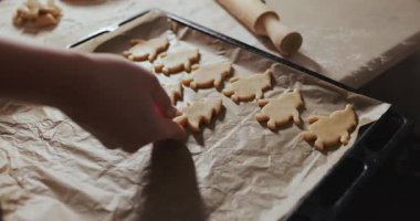 Ev hanımı kurabiye tepsisine kurabiye figürleri koyar. Sesli video.