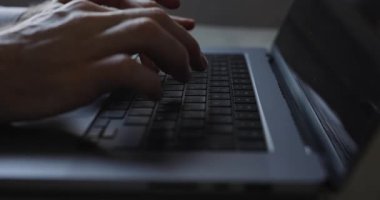 Eller dizüstü bilgisayarın klavyesinde yazı yazıyor. Video özgün ses içeriyor.