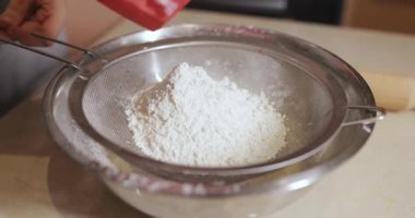 Kadın elleri süzgeçten un döker. Video özgün ses içeriyor.