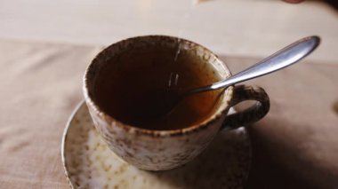 Bir fincan çaya şeker dök, ağır çekimde.