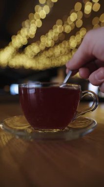 Ahududu çay fincanında şekeri karıştırmak, yavaş çekim dikey video