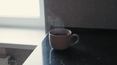 Bir fincan kahve pencerenin yanındaki masanın üstünde, yavaş çekimde 180 fp.