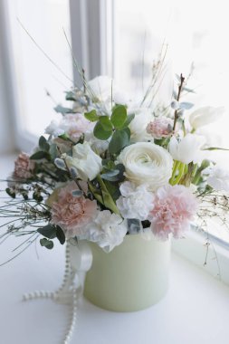 Pencere kenarında güzel bir buket ranunculus, karanfil ve lale çiçeği.