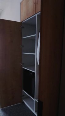 Beyaz bornoz ve terliklerle dolu bir otel dolabı.