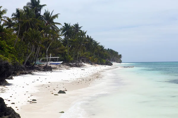 Unberührter tropischer Strand mit Palmen und Fischerbooten in Philippinen — Stockfoto