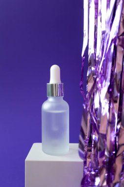 Pipetli serum modeli ve mor arka planda küp podyumda tatil süslemesi, dikey