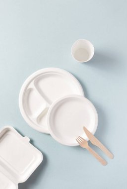 Plastiksiz tek kullanımlık sofra takımı üst görünümü, dikey. Kağıt tabak, yiyecek kapları, cam, tahta çatal, bıçak. Gübrelenebilir ya da ayrıştırılabilir yemek takımı
