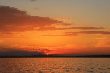 Gölün üzerinde güzel bir gün batımı. Sıcak bir yaz akşamında.