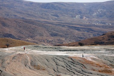 İnsanlar çamur yanardağının yanında yürür. Shemakha bölgesi. Azerbaycan.