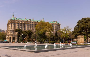 Bakü. Azerbaycan. 04.27.2022. Azneft Meydanı yakınlarındaki Bakü bulvarında kuğularla dolu bir çeşme..