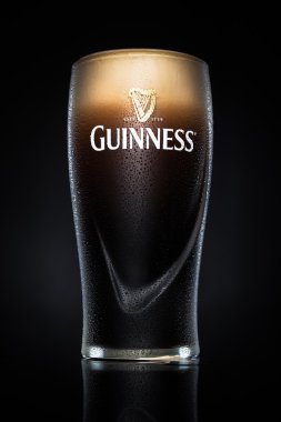 Pint of Guinness, the popular Irish beer on a black background. clipart