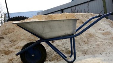 Talaş yığını, kereste fabrikasında ahşap talaşı. Yığınla taze, kuru çam talaşı. Ağaç atıkları bir bahçe arabasına doldurulur ve banliyö bölgesine taşınır..