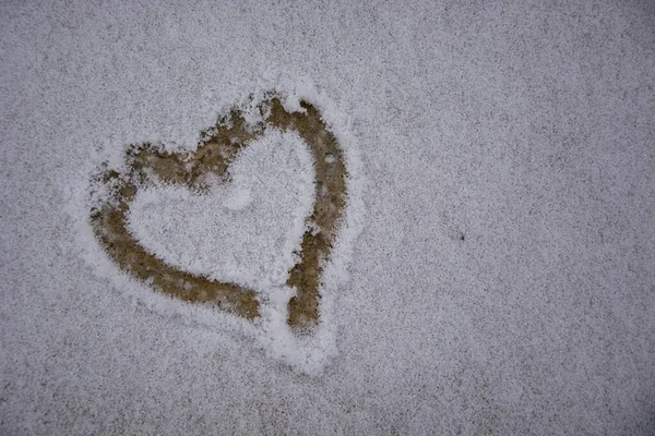 Heart in the snow. The heart is drawn with your finger on the newly fallen snow. Snow Declaration of love. Beginning of winter.