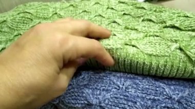 Ilık örülmüş şeyler. Örgü kumaşı elle okşuyorum. Örülmüş süveterler yığının içinde..