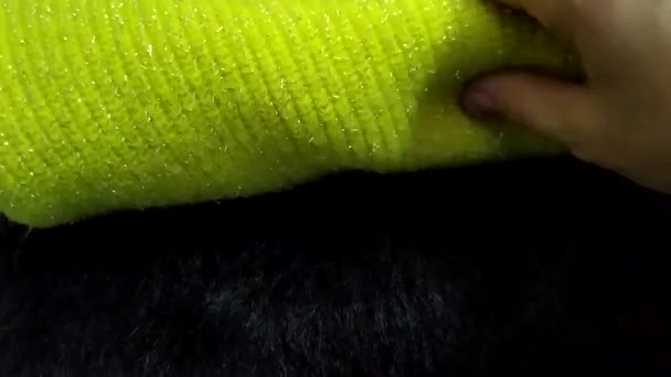 Das Mädchen wählt Strickstoffe nach ihren Eigenschaften aus. Strickpullover zu einem Stapel zusammengefaltet. Warme Strickkleidung. — Stockvideo