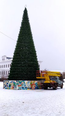 Rusya 'nın Rodniki kasabasında bir meydanda Noel ağacı dikmek. Noel ve Yeni Yıl için Aralık ayında bir Noel ağacı süslemek. Yayın fotoğrafı 2021.