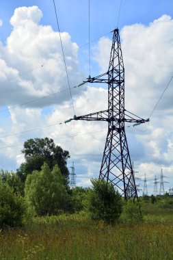 Yüksek voltajlı elektrik direği yakın plan. Kırsal kesimde elektrik hattı. Şehre elektrik sağlayan elektrik istasyonu. Dikey arkaplan.