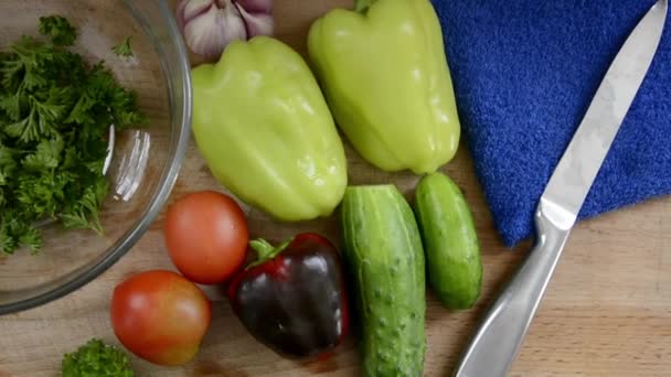 Свежие овощи для салата. Овощи на столе. Болгарский перец, огурцы и помидоры с травами для диетического питания. — стоковое видео