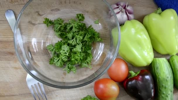 Свежие вымытые овощи на столе. Женская рука режет зелень для салата. Подготовка салата. Здоровые овощи, нарезанные на ломтики. — стоковое видео