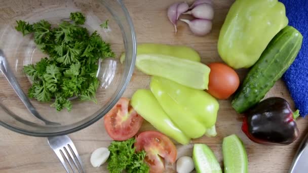 Salad preparation. Vegetables for the salad. Fresh washed vegetables are on the table. Bulgarian pepper, cucumbers and tomatoes with herbs for dietary nutrition. — Stock Video