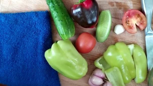 Gemüse für den Salat. Frisch gewaschenes Gemüse liegt auf dem Tisch. Bulgarischer Pfeffer, Gurken und Tomaten mit Kräutern für die Ernährung. — Stockvideo