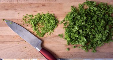 Maydanoz. Kesme tahtasındaki yeşiller. Salata için ince doğranmış maydanoz..