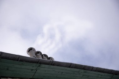 Bacadan gökyüzüne doğru duman çıkıyor. Bacadan bir duman bulutu yükseliyor. Kışın gaz ile tuğla bir evi ısıtmak.