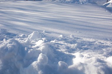 Kar yağışı yaklaşıyor. Güneşli bir günde karlı bir yüzey. Kış kar dokusu.