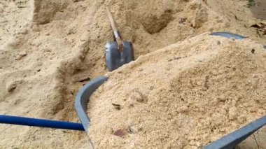 Bahçede talaş temizliyorum. Talaşlı bahçe arabası. Ahşap endüstrisinin atıkları..