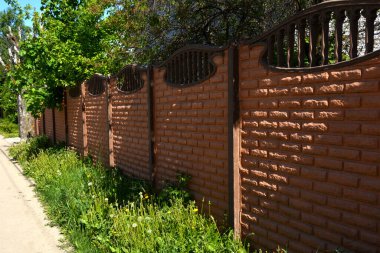 Çitlerin inşası. Konut binasının yakınındaki taş çit. Beton bariyer kur.