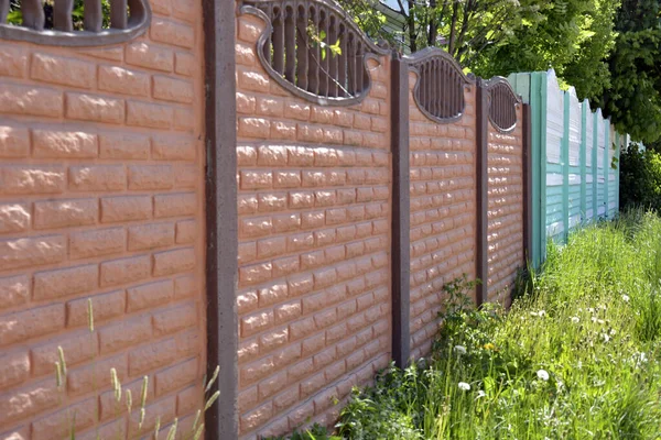 Kıvırcık çitlerin yapımı. Taş çit. Konut binasının yakınına beton çit dök..