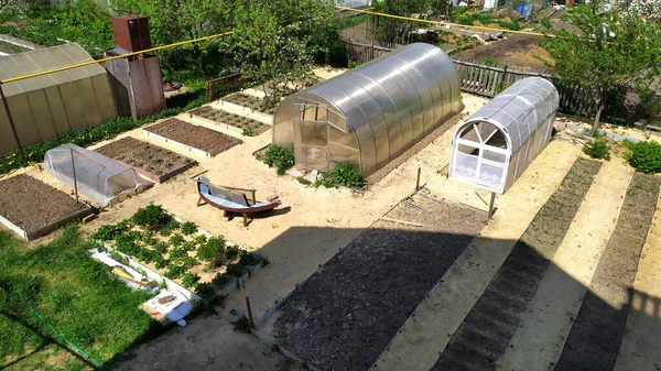 Bahçe bölgesinde sebzeli yatakların dağıtımı. Pürüzsüz uzun yataklar ve seralar. Sebze bahçesi manzarası.