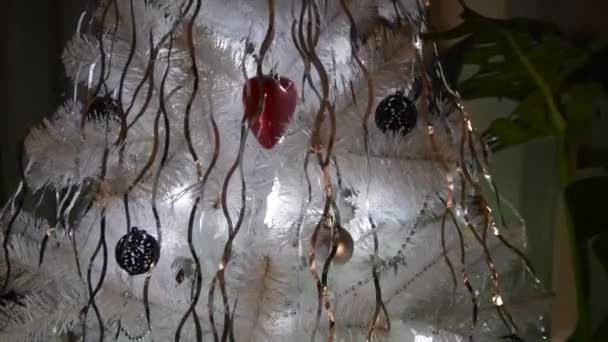 Το χριστουγεννιάτικο δέντρο είναι διακοσμημένο με γυάλινα παιχνίδια και fishnet μπάλες. Τα χριστουγεννιάτικα φώτα καίγονται στο δέντρο. Θέα από πάνω προς τα κάτω. Πρωτοχρονιά και Χριστούγεννα. — Αρχείο Βίντεο