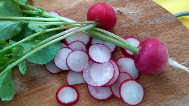 Ravanello si trova sul tavolo con fette e verdure a radice intera. — Video Stock