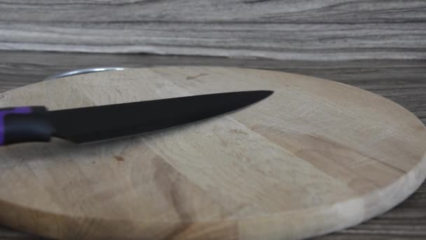 Cuchillo en el tablero. Una tabla de cortar vacía y un cuchillo de mesa se coloca en ella. — Vídeos de Stock
