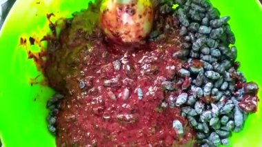 Patates püresinin içinde blender ile blender ile böğürtlenleri yen. Hanımeli kış için hasat yapıyor. Böğürtlen püresi yeşil bir tabakta.