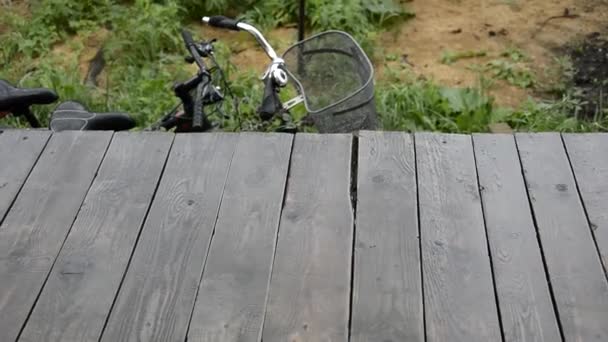 Lluvia. Caen gotas en el porche de madera. Otoño. Bicicletas de pie bajo la lluvia. — Vídeos de Stock