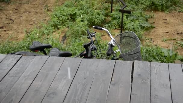 雨だ。水が木のポーチに落ちる。秋だ。自転車は雨の中に立つ. — ストック動画