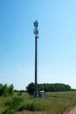 Metal pole of cellular communication. High-rise telephone pole in the middle of a field in the countryside.